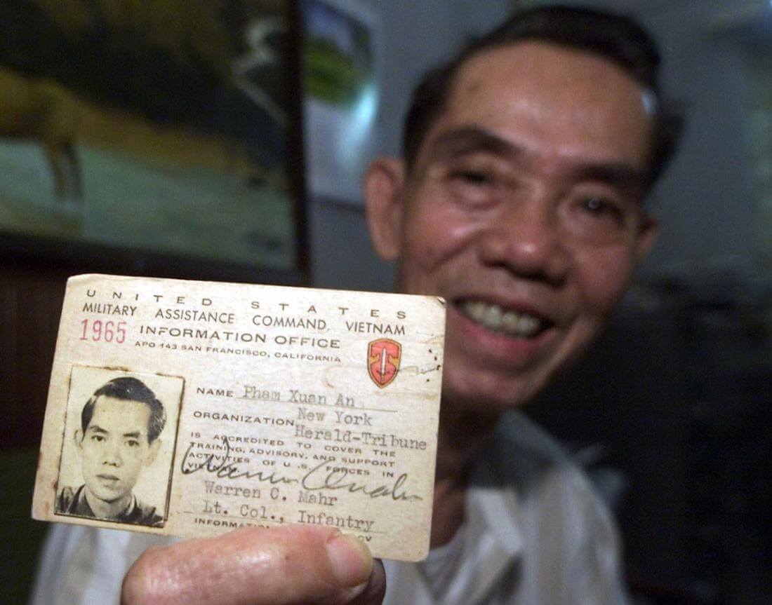 ** FILE ** Pham Xuan An holds up his press card from 1965 at his home in Ho Chi Minh City, Vietnam, in this April 26, 2000 file photo. Pham Xuan An, a Vietnamese who led a remarkable and perilous double life as a communist spy and a respected reporter for western news organizations during the Vietnam War, has died at a military hospital Wednesday, Sept. 20, 2006 in Ho Chi Minh City, his son said. An, 79, suffered from emphysema. (AP Photo/Charles Dharapak, File)